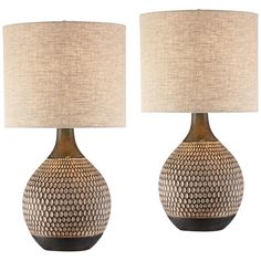 two lamps are sitting next to each other on a white background, one is brown and the other is beige