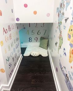 there is a small bed in the corner of this room with numbers painted on the walls