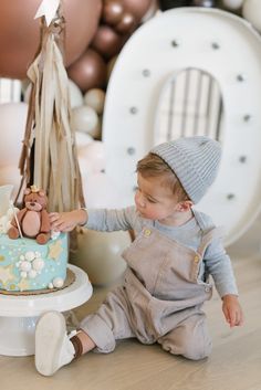 a little boy that is sitting in front of a cake