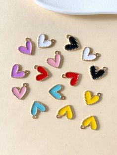 heart shaped pins sitting on top of a white table next to a plate and spoon