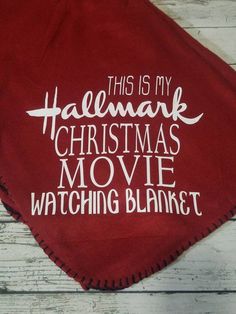 this is my halemak christmas movie watching blanket on a wooden floor with white lettering