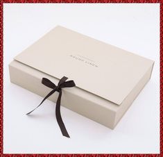 a white box with a black ribbon tied around it