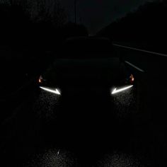 two headlights on the side of a road at night