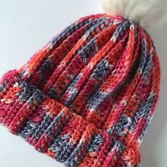 a crocheted hat with a white pom - pom on the top