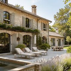 an outdoor patio with chaise lounges and water feature in front of the house