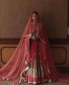 a woman in a red bridal gown and veil