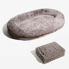 two dog beds with fur on them, one is pink and the other is grey