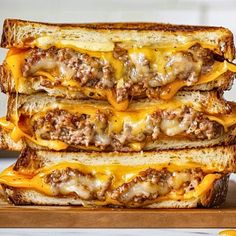 three grilled cheeseburger sandwiches stacked on top of each other with melted cheese