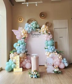 balloons and decorations are arranged in the shape of an arch for a baby's first birthday party