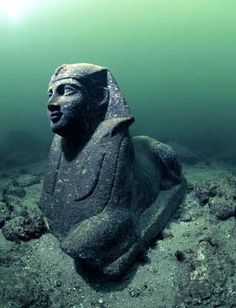 four different images of statues in the water and underwater with sunlight shining on them, including one of which has a lion statue