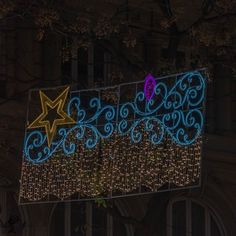 a large sign that is lit up in blue and pink with stars hanging from it's sides