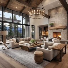 a living room filled with furniture and a fire place in front of a window overlooking the mountains