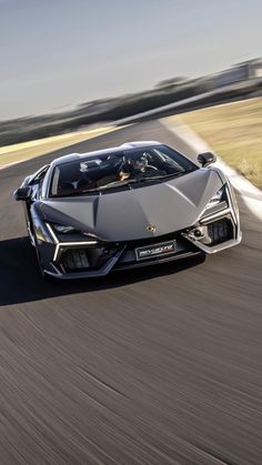 a silver sports car driving down the road