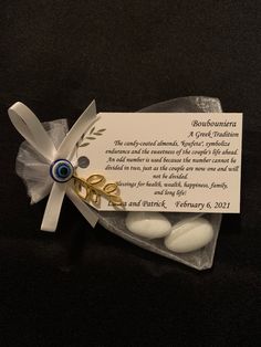 a card and some white rocks on a black surface with a ribbon around it that says doubuntra