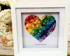 a white frame with a rainbow heart in it