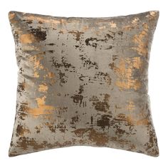 a grey and gold pillow with an abstract design