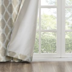 an open window with white and blue curtains