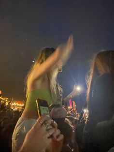 a group of people standing next to each other in front of a crowd at night