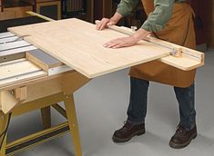 a man in an apron is working on a workbench with a table saw