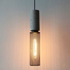 a light that is hanging from a wire on the wall next to a lamp shade