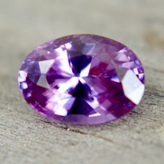 a purple diamond sitting on top of a wooden table