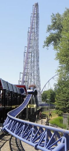 the roller coaster is blue and has a long slide going up it's side