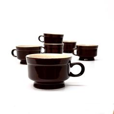 Deep brown cups, group of 6.   These deep brown ceramic cups with a cream interior are made in Japan, a beautiful set of stoneware from the 1970's.  Height: 2.75"  Width: 4" Minimalist Bedroom Furniture, Ceramic Cafe, Brown Mugs, Cream Interior, Brown Cups, Cafe Cup, Modern Mugs, Dish Storage, Kitchen Goods