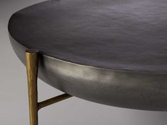 a close up of a metal table with a wooden base and gold legs on it