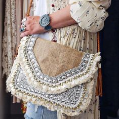 The original banjara classic. Ethically made with love, the White Sands sling bag comes with intricate beadwork, and is the perfect cocktail party companion. With its playful design and neutral beauty, this boho bag is made with eco-friendly jute fabric and will add such life to any outfit. Color: Cream, Tan, Bronze, Silver, White Material: Eco Friendly Jute, Cotton, Brass, Glass Beads Bag Measurements: 29cm x 22cm Sling Measurements: Approx 100cms Banjara Beaded Bag | Boho Beaded Bag | Boho Beaded Clutch | Festival Bag | Jute Beaded Clutch Bag Boho Sling Bag, Boho Clutch Bag, Tan Crossbody Bag, Boho Clutch, Beaded Clutch Bag, Embroidered Cross, Mode Boho