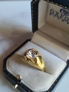 an engagement ring in a box on top of a white table with the lid open