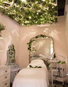 a room with a bed, mirror and plants on the ceiling