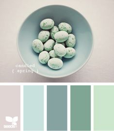 a bowl filled with green and white candies on top of a table next to two color swatches