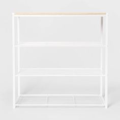 a white shelving unit with two shelves on one side and a wooden shelf on the other