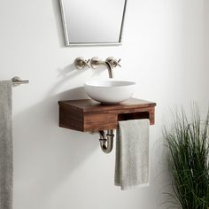 a white bowl sink sitting on top of a wooden counter next to a towel rack