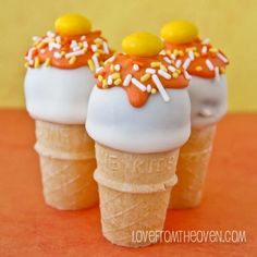 three ice cream cones topped with sprinkles and candies on top of each other