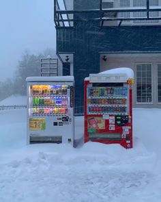 two vending machines covered in snow next to a building