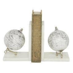 two globes are sitting on top of a bookend, one is white and the other is brown