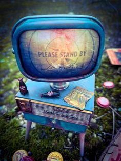 an old fashioned tv sitting on top of a table next to buttons and magnets