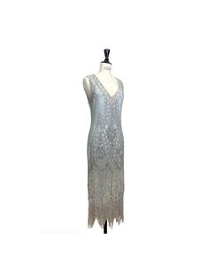 The epitome of Art Deco design...our Icon Gown is positively decadent! With a deep v neckline, the Icon features front and back panels accented with a sparkling floral design. The gown is finished with a scalloped hem dripping with beaded fringe.  It is the classic flapper look for a modern woman. The Icon is one of our best selling dresses for a reason! Cutout design on the upper back. Full-Length.  Matching slip included. Sbust 33-35", waist 29-31", hips 38-40", length 50" Mbust 36-38", waist Elegant Beaded Dresses For Vintage Events, Beaded Gatsby Style Wedding Dress, Beaded Gatsby Wedding Dress, Elegant Embellished V-neck Flapper Dress, Embellished V-neck Fitted Flapper Dress, Vintage V-neck Evening Dress For Formal Occasions, Vintage V-neck Sequin Dress, Beaded V-neck Evening Dress For Wedding, Vintage Beaded Floor-length Dress