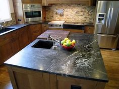 a bowl of fruit sitting on top of a kitchen counter