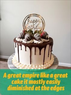 a birthday cake with chocolate icing and strawberries on top is displayed in front of a sign that says happy birthday