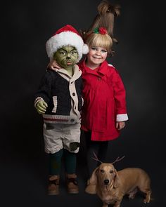 two children in costumes standing next to a dog