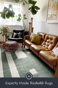 a living room with two couches and a rug on the floor in front of a window