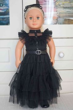 the doll is wearing a black dress with ruffles