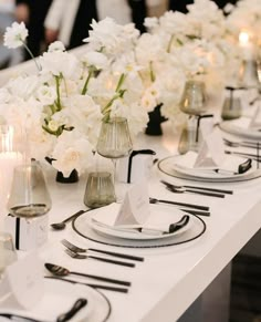 a long table with white flowers and place settings