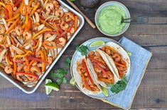 shrimp tacos and guacamole on a wooden table