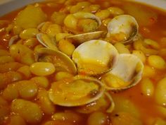 a white bowl filled with stew and clams