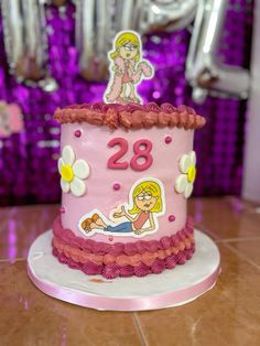 a pink birthday cake with a cartoon figure on top and the number 28 on it