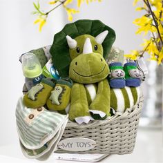 a green stuffed animal sitting in a basket