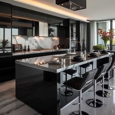 a modern kitchen with black cabinets and marble counter tops, along with bar stools